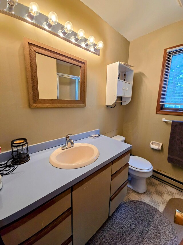 full bath featuring a baseboard radiator, toilet, vanity, tile patterned floors, and a stall shower