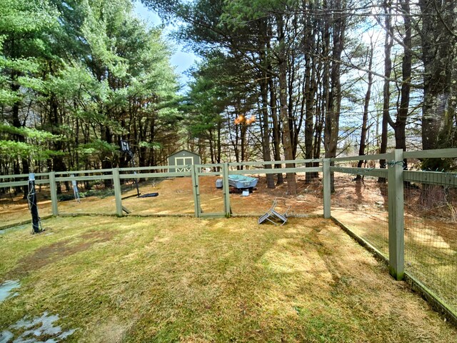 view of yard with a storage unit, fence, and an outdoor structure