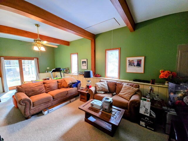 living room with beam ceiling, carpet, attic access, and a ceiling fan