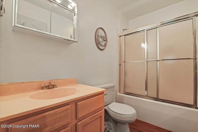 full bath with shower / bath combination with glass door, vanity, and toilet