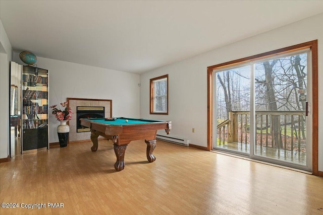 recreation room with a baseboard heating unit, pool table, a tile fireplace, and wood finished floors