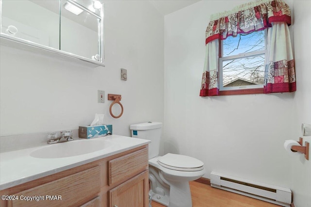 bathroom featuring toilet, baseboard heating, wood finished floors, and vanity