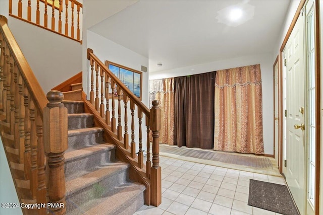 foyer with light tile patterned floors and stairway