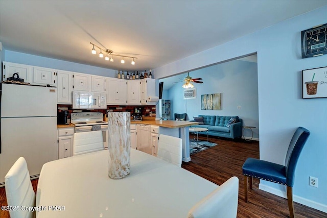 kitchen with white appliances, ceiling fan, white cabinetry, dark hardwood / wood-style floors, and kitchen peninsula