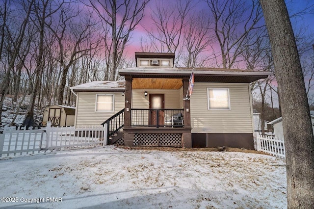 view of front of property with a porch and a storage shed