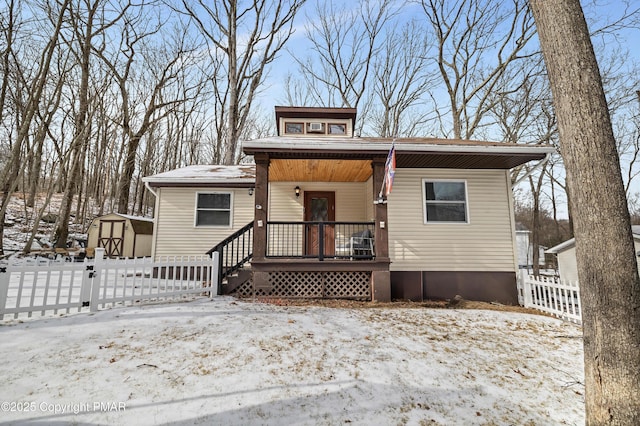 view of front of house featuring a porch and a storage shed