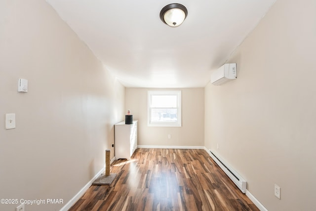 spare room with baseboard heating, a wall mounted air conditioner, and dark hardwood / wood-style floors