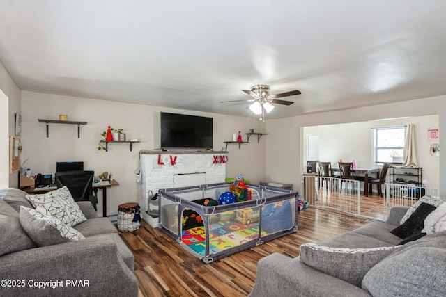 living room with ceiling fan, dark hardwood / wood-style floors, and a fireplace