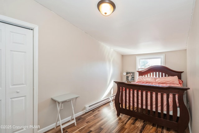 bedroom featuring a baseboard heating unit and hardwood / wood-style floors