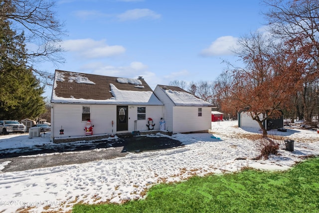 snow covered property featuring an outbuilding