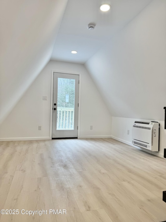 bonus room featuring vaulted ceiling, wood finished floors, and heating unit