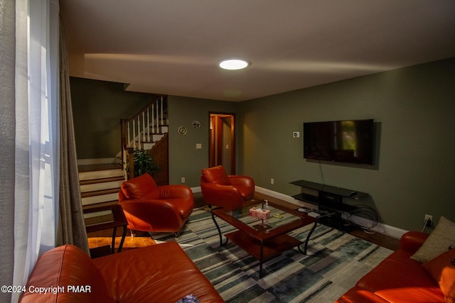 living area with baseboards and stairway