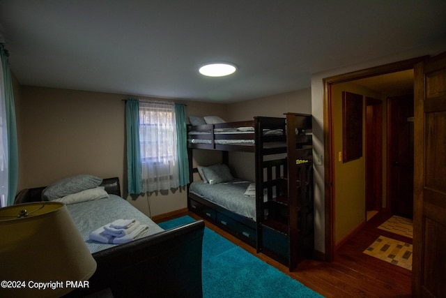 bedroom with baseboards and wood finished floors