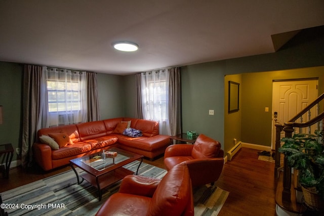 living area with a baseboard radiator, a healthy amount of sunlight, stairway, and wood finished floors