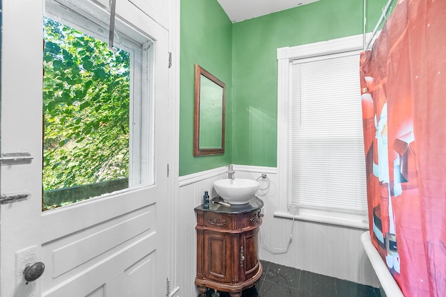full bathroom with tile patterned floors, a wainscoted wall, and vanity