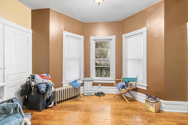 interior space with radiator, wood finished floors, and baseboards
