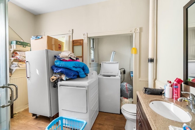 washroom with laundry area, washing machine and clothes dryer, and a sink