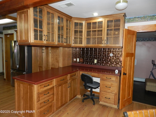 office space featuring light wood finished floors, visible vents, and a baseboard heating unit