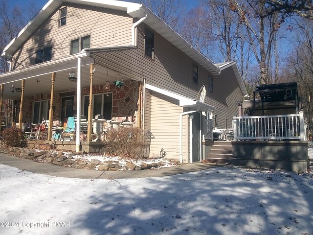 view of snow covered exterior featuring covered porch