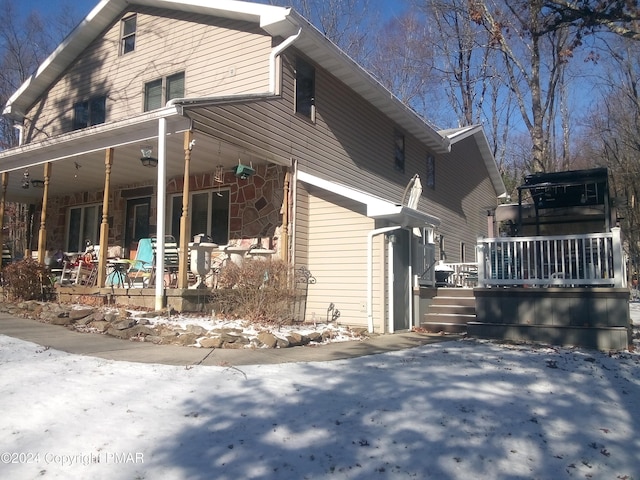 snow covered property featuring stone siding