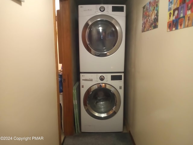 clothes washing area featuring laundry area and stacked washer / dryer