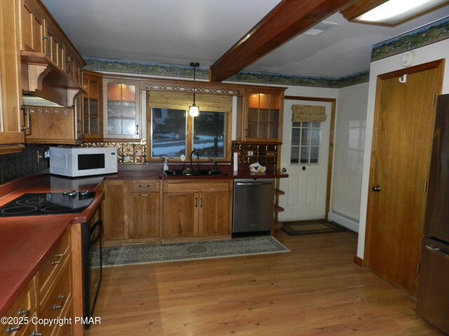 kitchen featuring pendant lighting, sink, light hardwood / wood-style flooring, beam ceiling, and stainless steel appliances