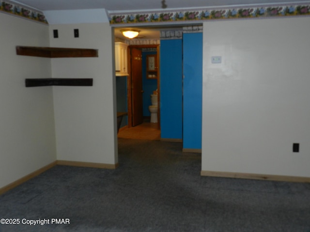 unfurnished room featuring carpet and baseboards