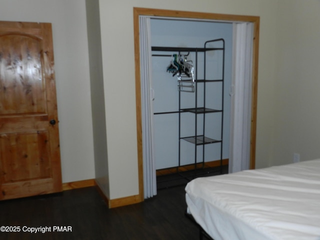 bedroom featuring baseboards and dark wood-style flooring