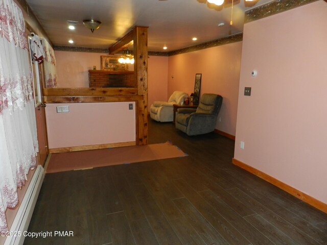 basement featuring dark wood-type flooring and a baseboard heating unit