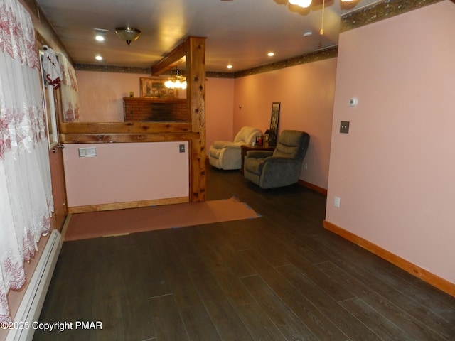 unfurnished living room featuring recessed lighting, a baseboard radiator, wood finished floors, and baseboards