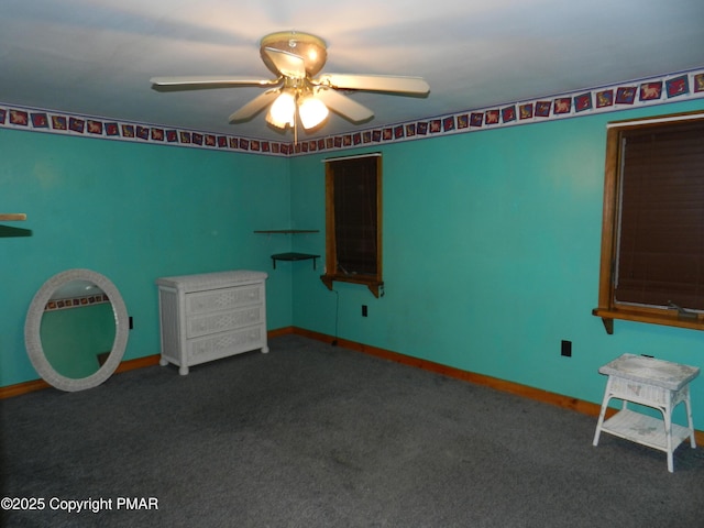 interior space with carpet floors, a ceiling fan, and baseboards