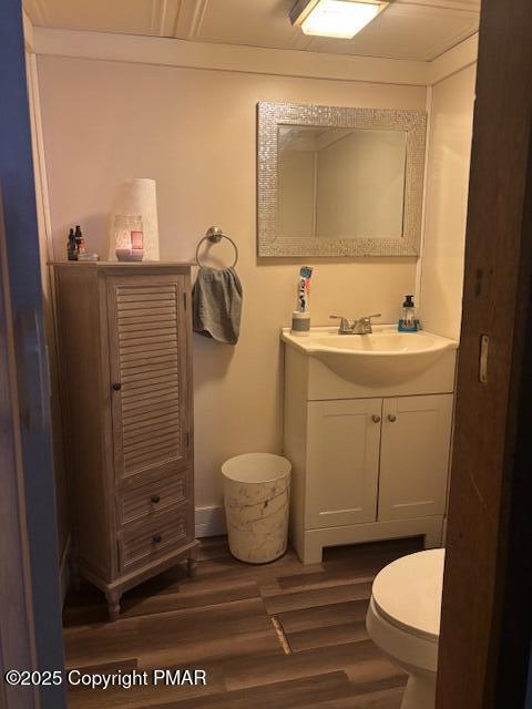 bathroom with hardwood / wood-style flooring, vanity, and toilet