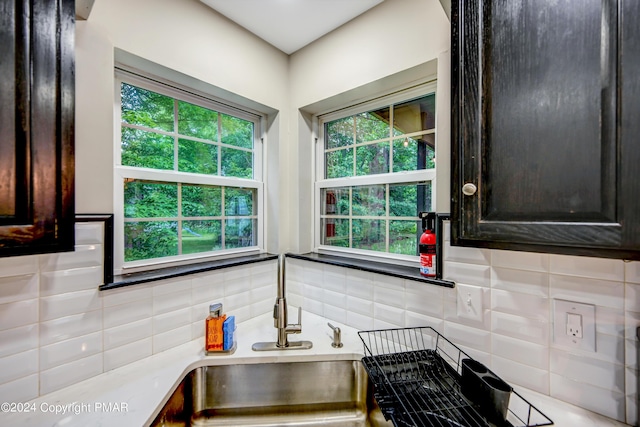 kitchen featuring tasteful backsplash, dark brown cabinetry, and a sink