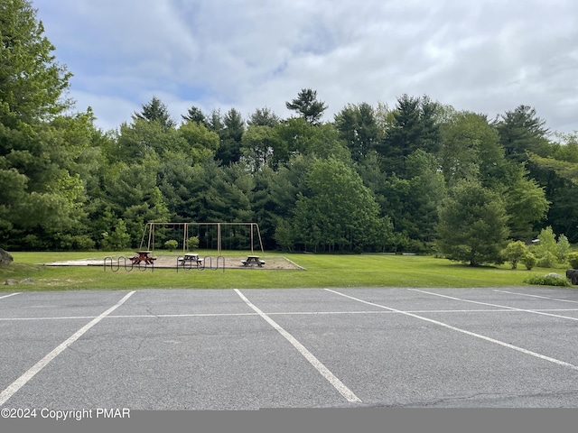 view of car parking featuring playground community