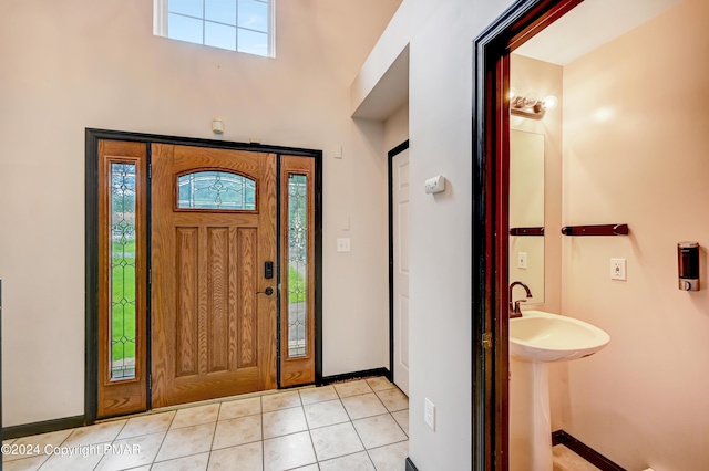 foyer entrance with baseboards and light tile patterned floors