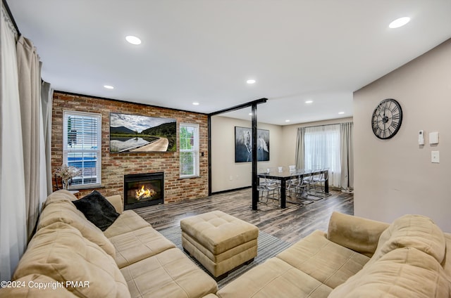 living area featuring a brick fireplace, brick wall, wood finished floors, and recessed lighting