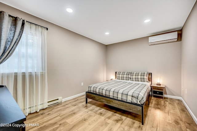 bedroom featuring light wood-style floors, baseboards, an AC wall unit, and recessed lighting