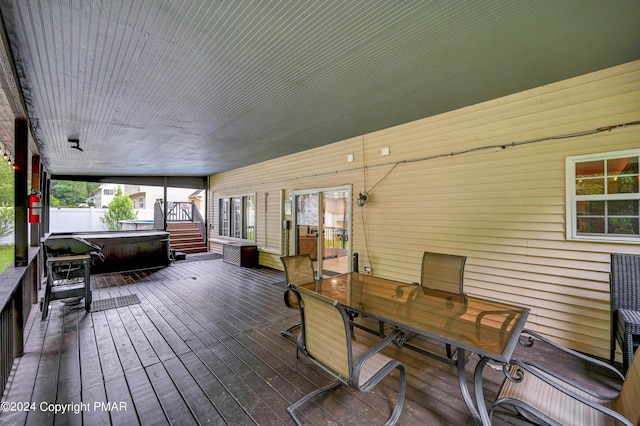 deck featuring outdoor dining area and a hot tub