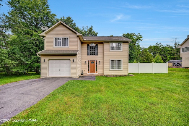 traditional-style home featuring an attached garage, fence, a front lawn, and aphalt driveway