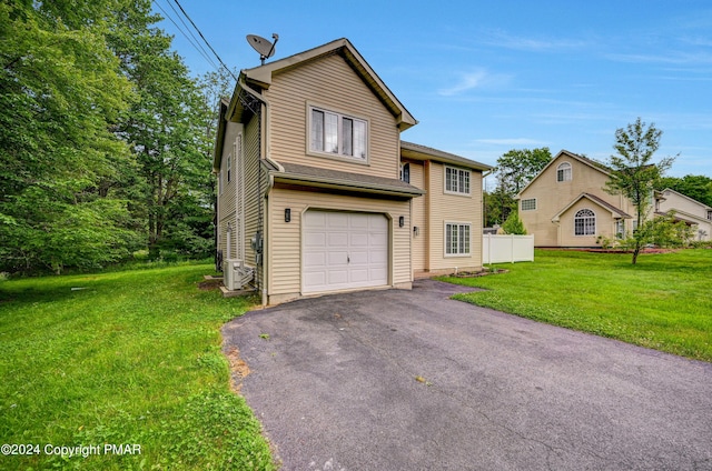 view of front of home featuring a front lawn, ac unit, an attached garage, and aphalt driveway