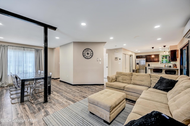 living area with baseboards, wood finished floors, and recessed lighting