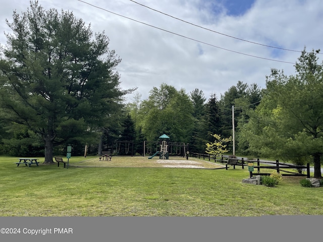 view of property's community featuring playground community and a yard