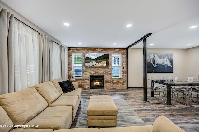 living area featuring brick wall, a fireplace, wood finished floors, and recessed lighting