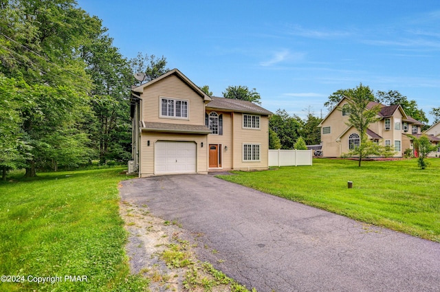 view of front of property featuring aphalt driveway, a garage, fence, and a front lawn