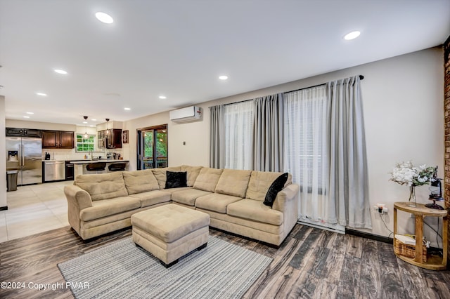 living area featuring light wood-type flooring, an AC wall unit, and recessed lighting