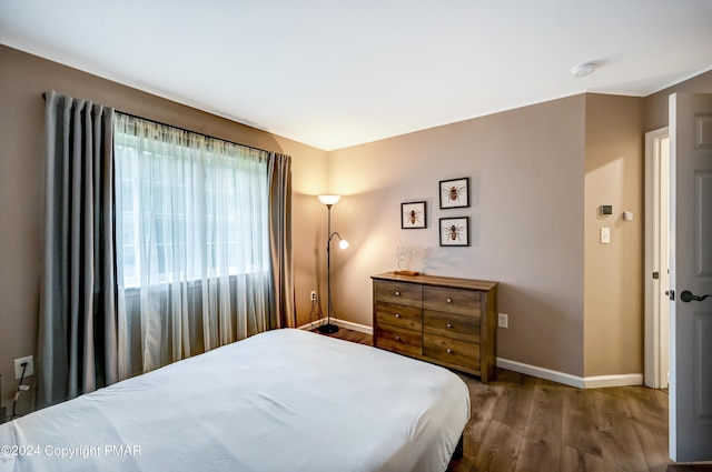 bedroom with baseboards and wood finished floors