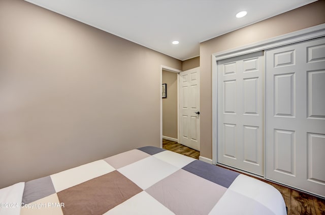 bedroom with a closet, baseboards, dark wood-type flooring, and recessed lighting