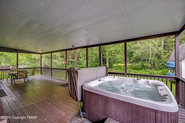 wooden terrace with outdoor dining space and a hot tub