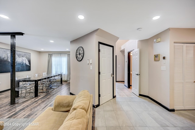 corridor featuring light tile patterned flooring, baseboards, and recessed lighting