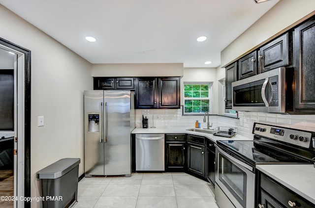 kitchen featuring light tile patterned floors, recessed lighting, decorative backsplash, appliances with stainless steel finishes, and a sink